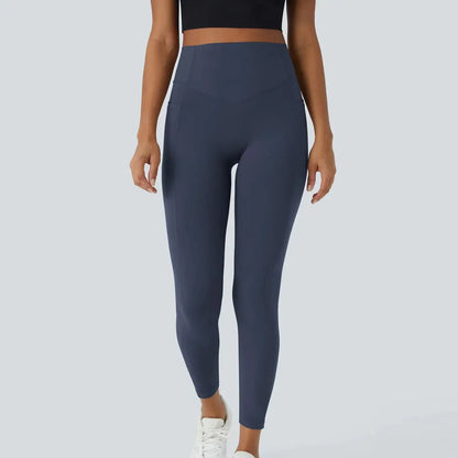 Person wearing dark blue leggings on a light gray background